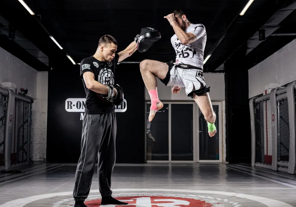 Kickboxing training with a partner and focus mitts in a gym